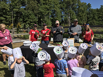 Volunteers working with children on an activity at farm for Service Day